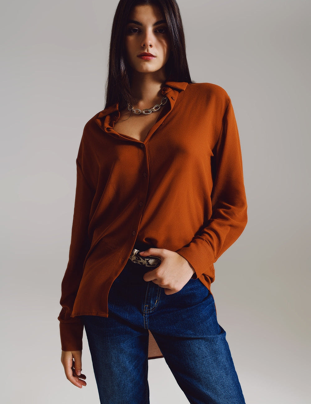 Woman wearing Cymirel Chiffon Polo Blouse in camel, showcasing relaxed fit and elegant design for versatile styling.