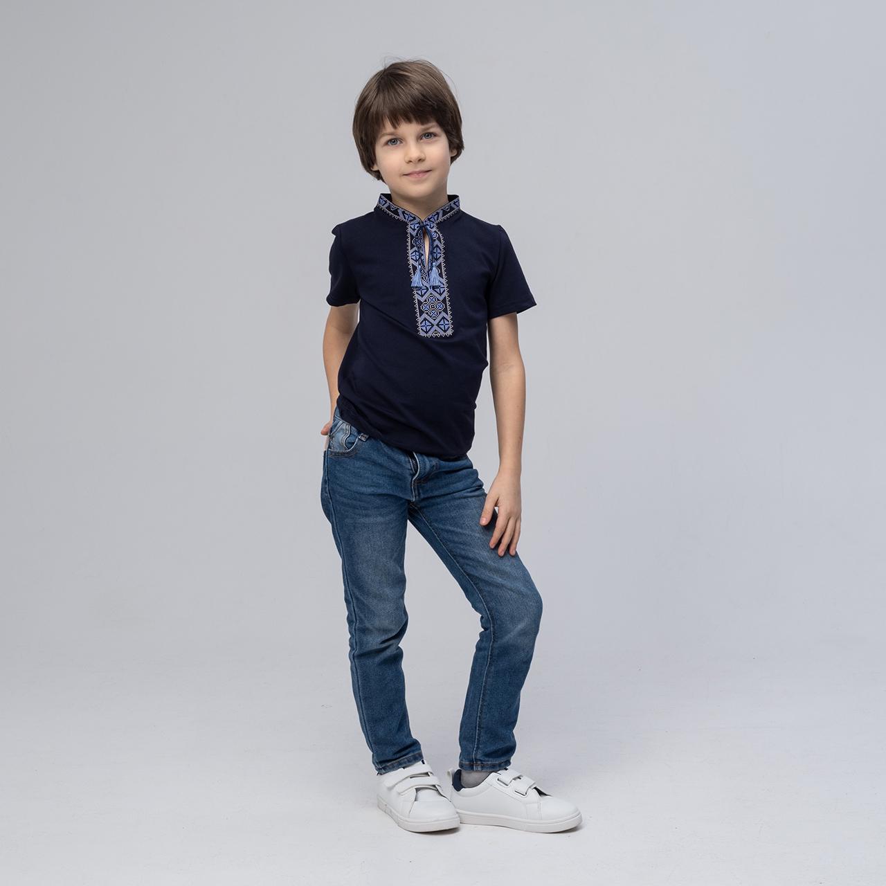 Boy wearing dark blue T-shirt with traditional Ukrainian blue embroidery and jeans, showcasing the Kozatska pattern.