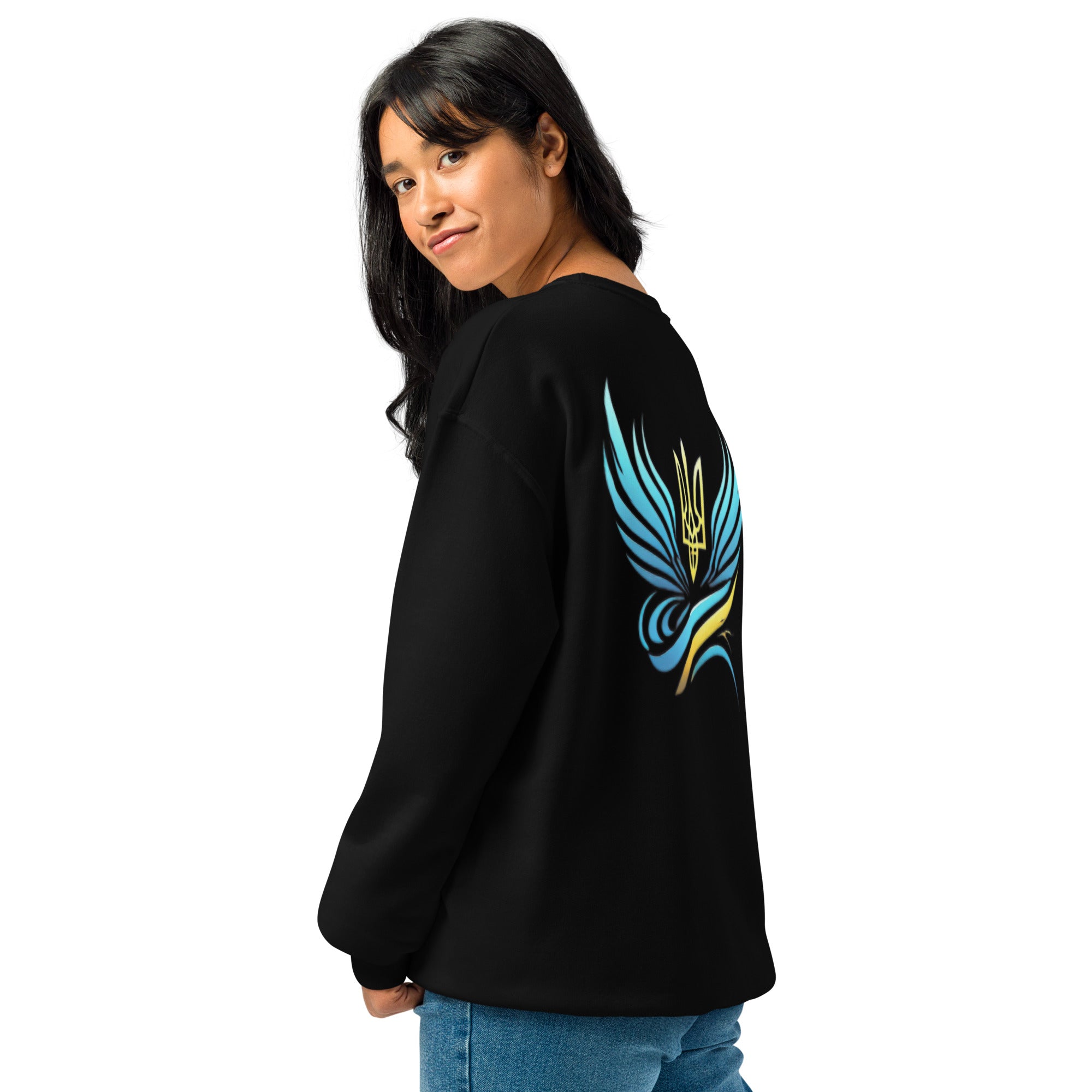 Woman wearing a black sweatshirt with a blue and yellow trident logo design on the back, paired with blue jeans.