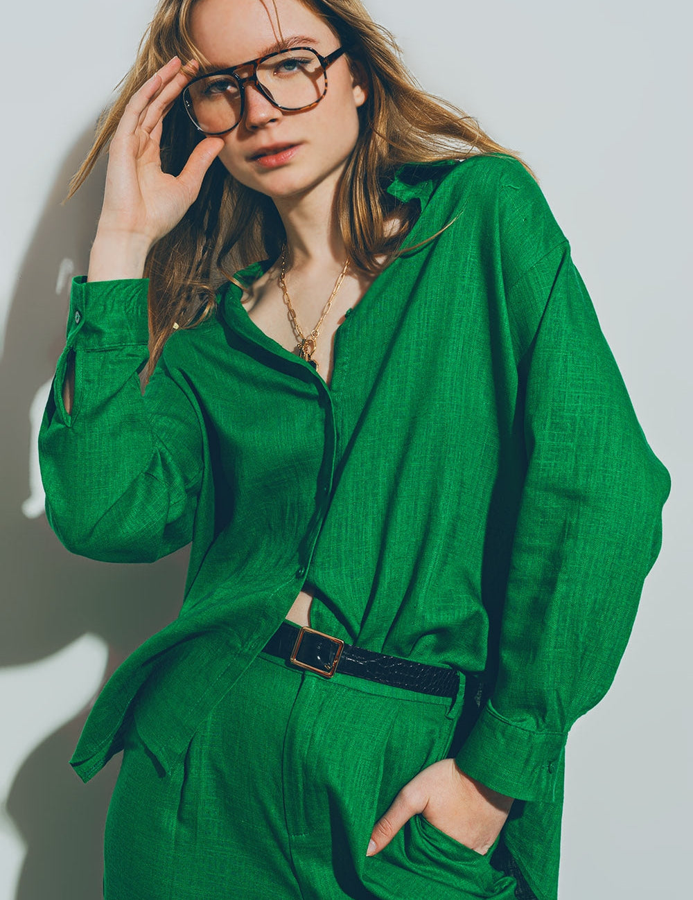 Woman wearing Theryn Relaxed Cotton Shirt in green, styled with trousers, showcasing laid-back, breathable design and comfort.