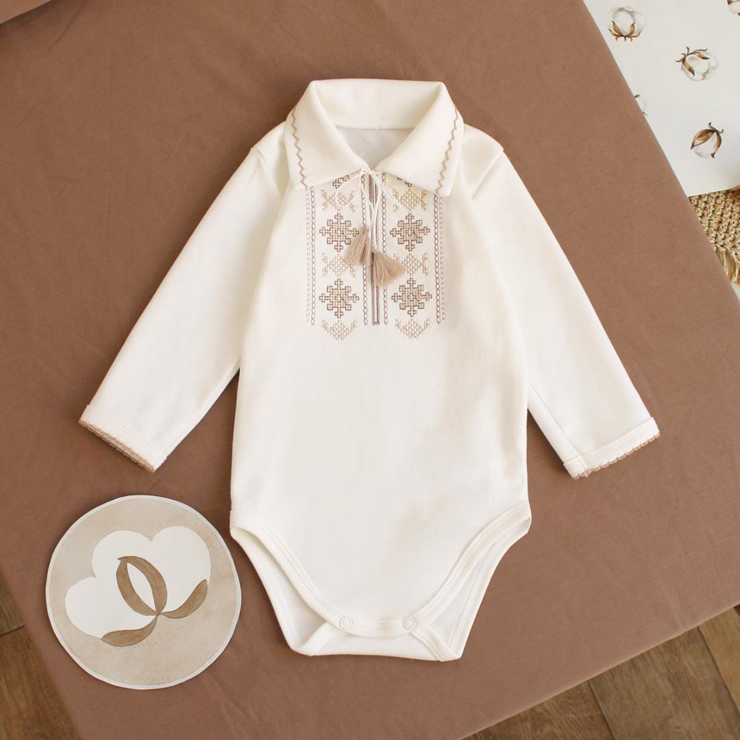 Cream Ukrainian embroidered long sleeve baby onesie with Vyshyvanka design, perfect for special occasions and baby gifts.