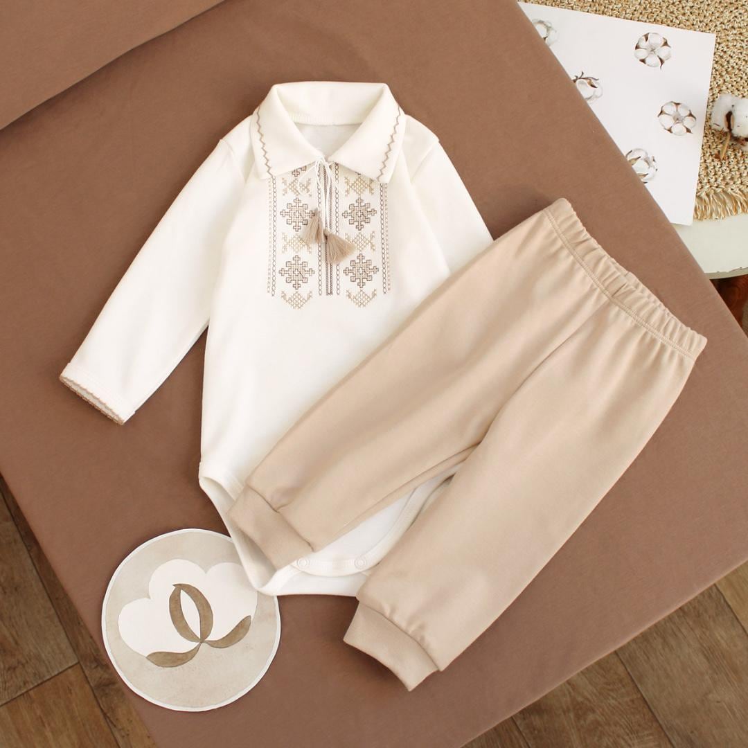 Cream Ukrainian embroidered baby boy onesie with beige pants, featuring traditional Vyshyvanka design, perfect for special occasions.