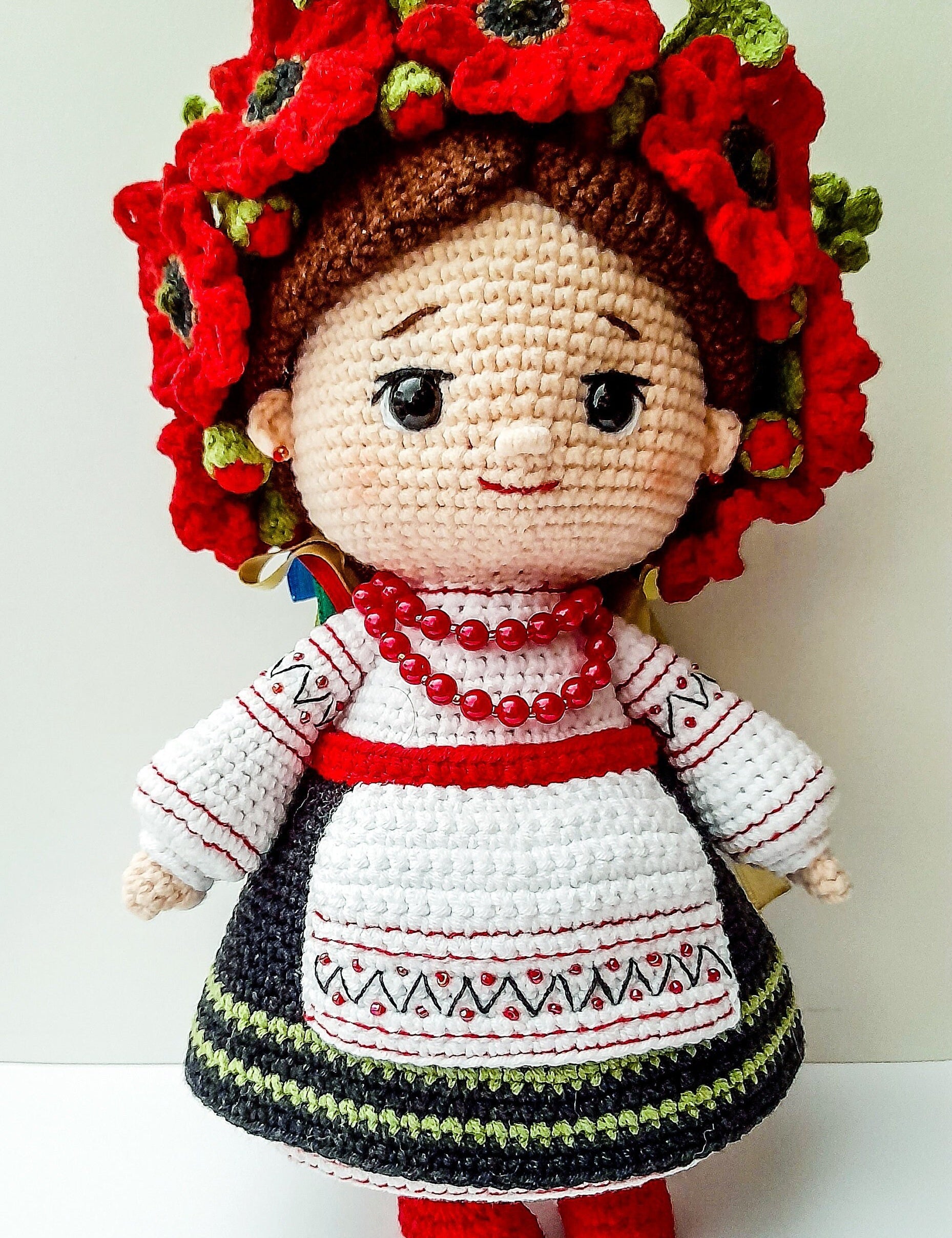 Handmade crochet Ukrainian doll in traditional attire with red flowers, a unique souvenir gift.