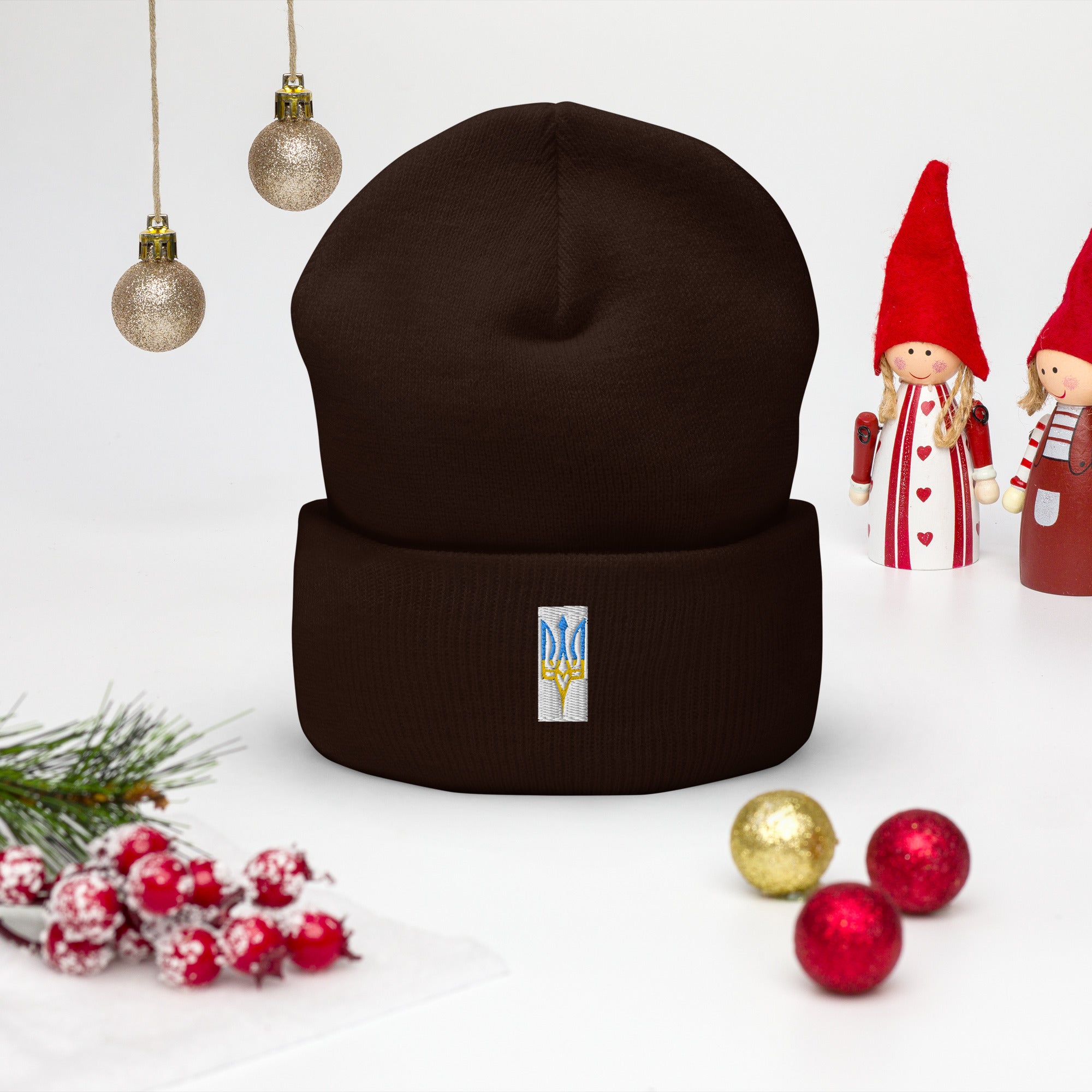 Unisex cuffed beanie with embroidered Ukrainian Tryzub emblem, displayed with holiday decorations.