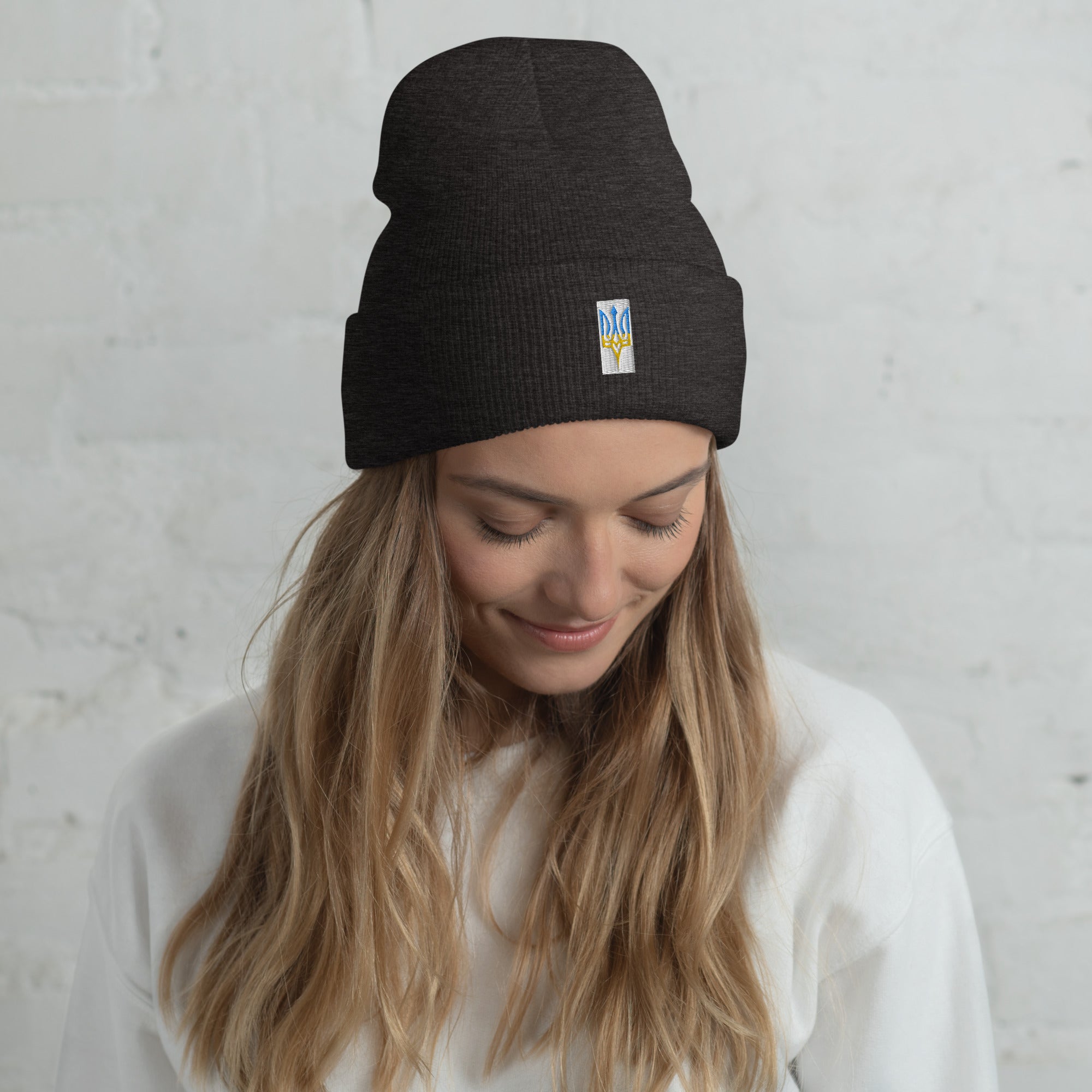 Woman wearing unisex cuffed beanie with embroidered Ukrainian Tryzub emblem, showcasing stylish and comfortable winter fashion.
