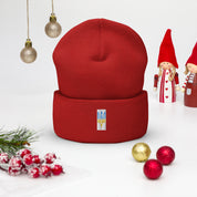 Red unisex cuffed beanie with embroidered Ukrainian Tryzub, surrounded by festive holiday decorations.