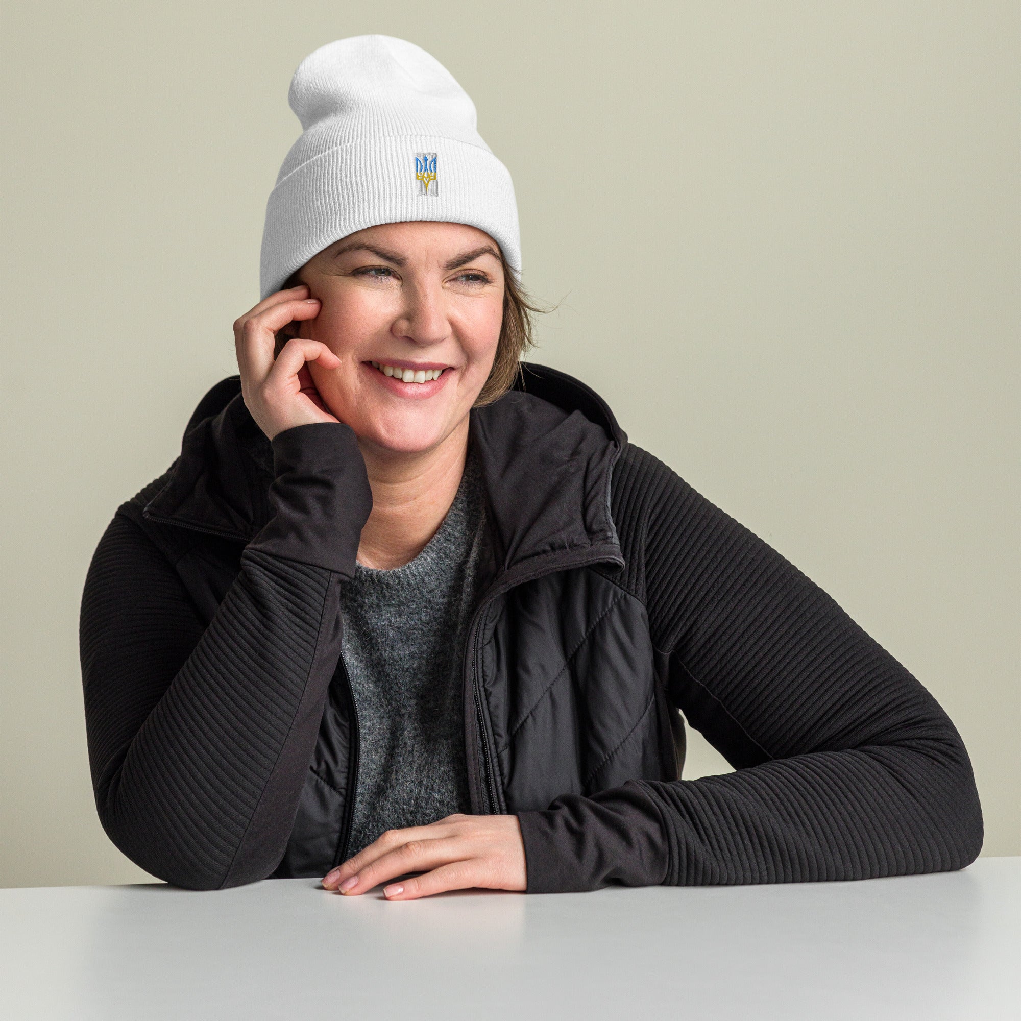 Unisex cuffed beanie with Ukrainian Tryzub emblem worn by woman, showcasing casual outfit and style.