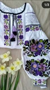 Traditional Ukrainian Vyshyvanka blouse with floral embroidery on white fabric, surrounded by daffodils.