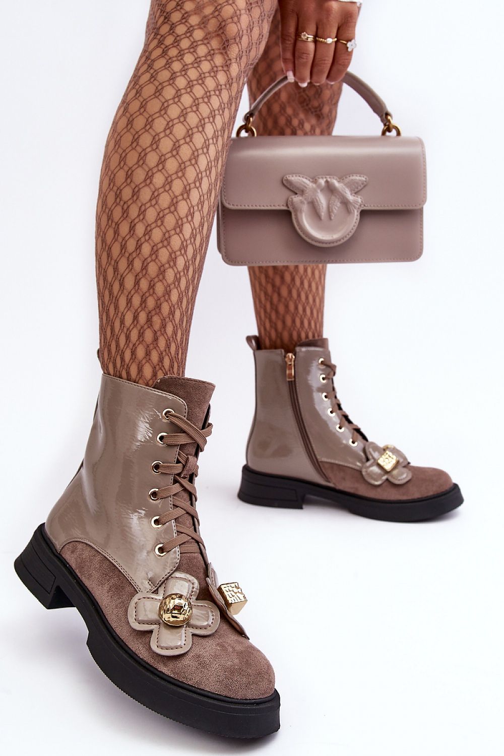 Woman wearing Florynne Floral-Laced Winter Boots with patterned tights and holding a matching taupe handbag.