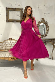 Woman wearing a Marleia Mesh-Layered Evening Midi Dress in deep pink with sheer long sleeves and a flared skirt in an elegant setting.