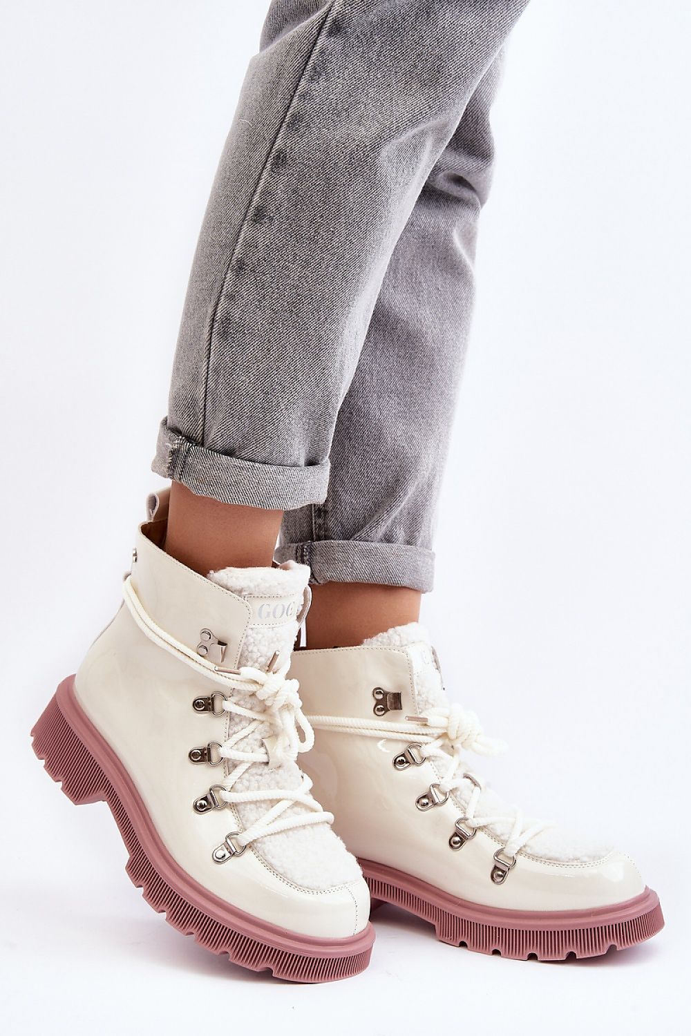 Person wearing Larkwood Trapper Boots with natural leather and sheepskin details, featuring a lace-up design and durable flat heel.