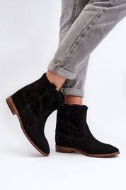 Woman wearing Meredia suede slip-on flat boots with a concealed wedge and rounded toe, perfect for casual and minimalist chic outfits.