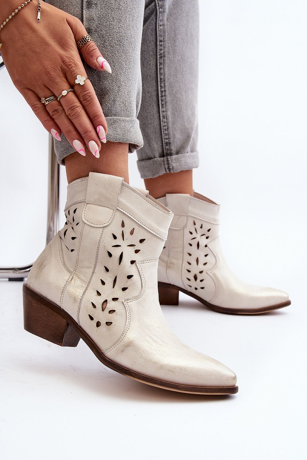 Woman wearing Riverta Leather Western Ankle Boots in natural leather, showing pointed toe and 5 cm heel, paired with grey rolled-up jeans.