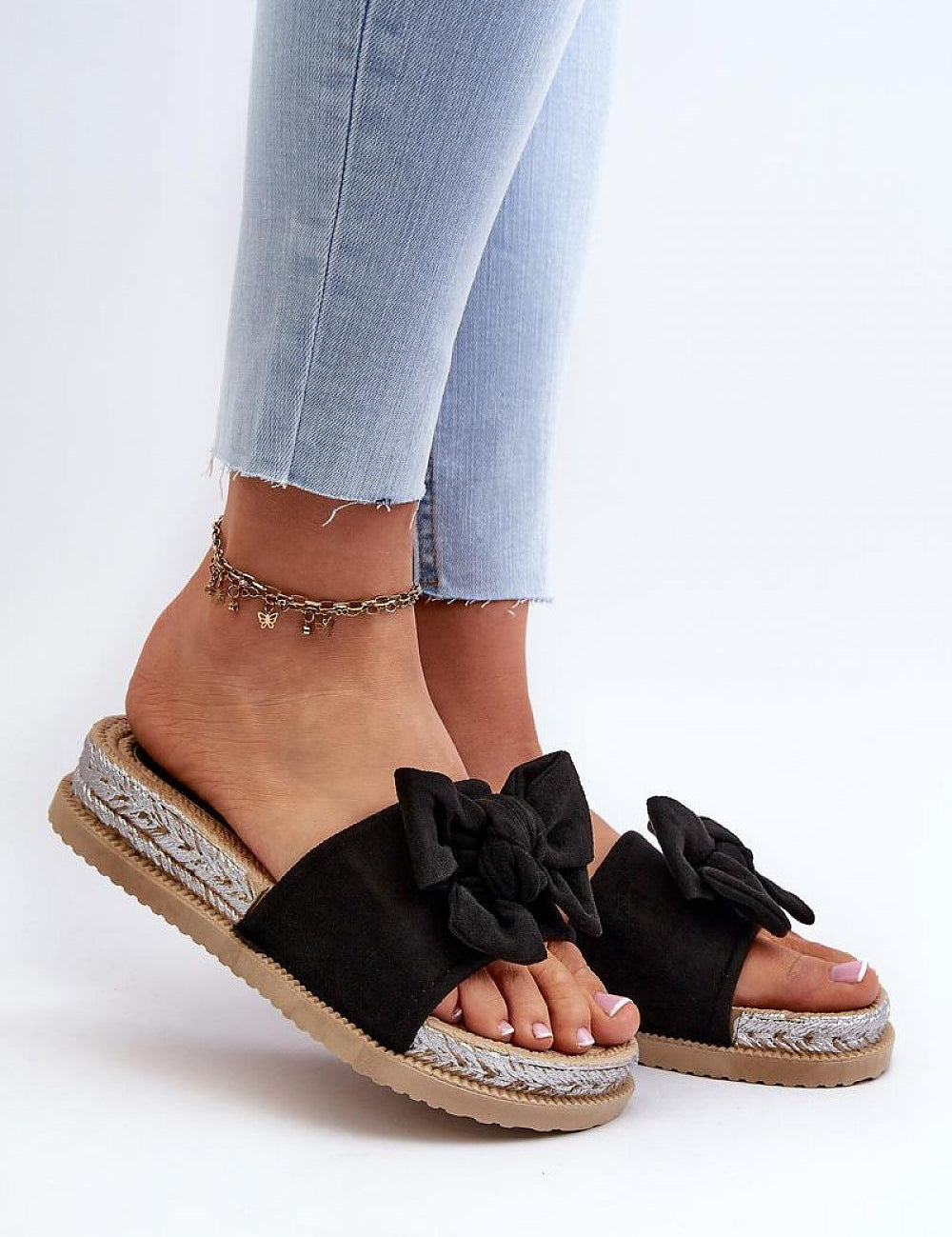 Alinara Suede Knot Platform Slides in black eco-suede, featuring a graceful bow, worn with light jeans on relaxed summer days.