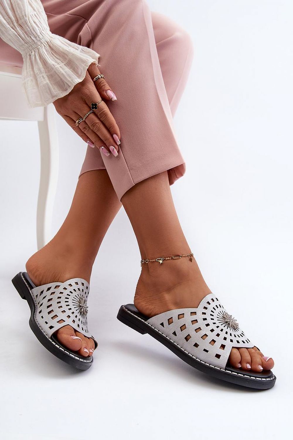 Woman wearing Orletta Flat Slides with cutout detail and eco leather, showcasing minimalist style and low heel for comfort.