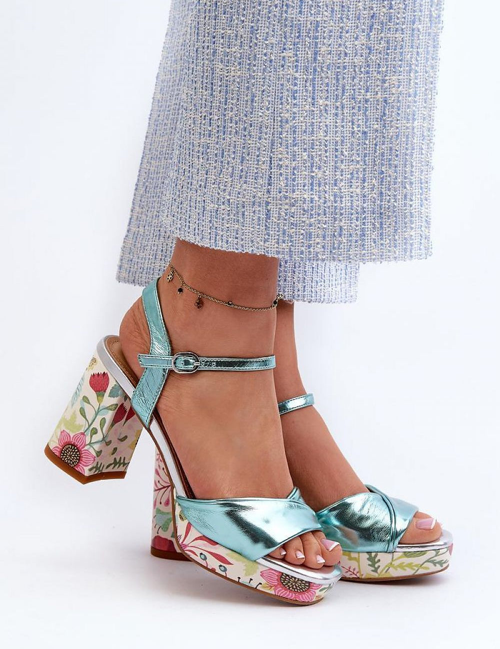 Florvella Patterned Block Heel Sandals with floral design and adjustable buckle strap worn with blue pants.