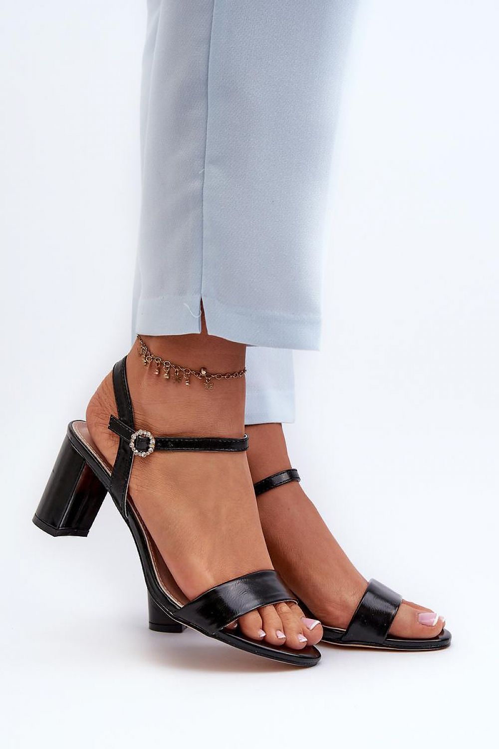 Woman wearing Zarellia Metallic Strap Post Heel Sandals with decorative buckle and eco leather upper, showcasing elegance and comfort.