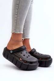Rivaya Sculpted Foam Slides with platform design, worn with jeans, showcasing bold lines, cushioned foam for comfort and style.