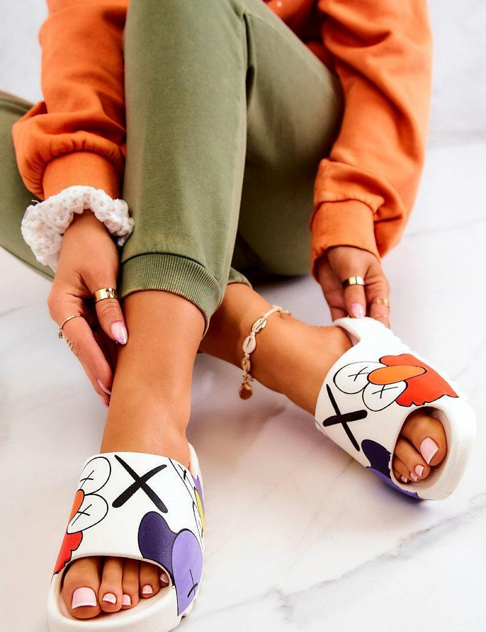 Woman wearing Mifla Cartoon Rubber Summer Slides with vibrant design, showcasing playful comfort and style on a marble floor.