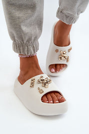 Floriva Thick-Sole Foam Flip-Flops with decorative accents, featuring a 5.5 cm platform, worn with casual grey pants for a stylish look.