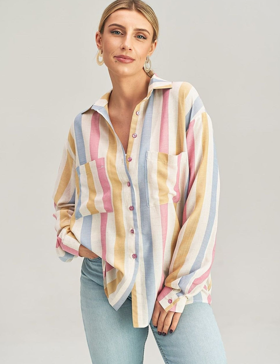 Woman wearing Maelora Asymmetrical Pocket Shirt with pastel stripes and decorative buttons.