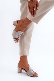 Woman wearing Solvera Heeled Suede Flip-Flops with 5.5 cm heel and minimalist design, paired with light trousers.