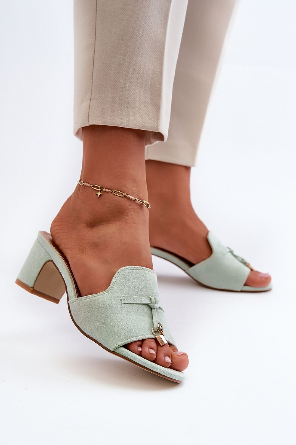 Woman wearing Solvera heeled suede flip-flops with a 5.5 cm heel, showcasing minimalist design and eco-suede finish, stylish and comfortable.