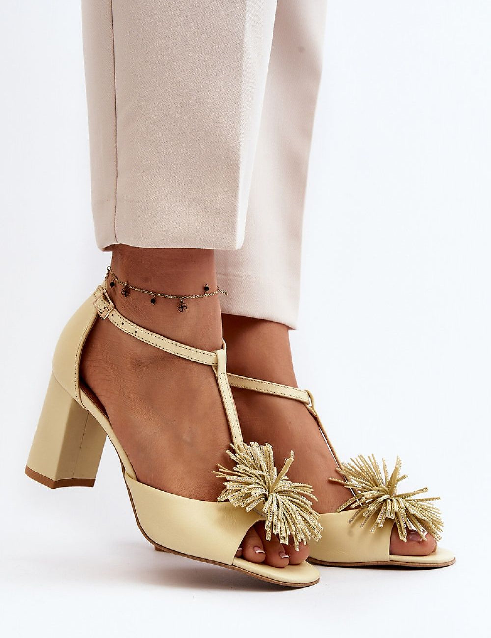 Woman wearing Alessira Post-Heel Leather Sandals with delicate front ornament and adjustable ankle strap for a refined look.