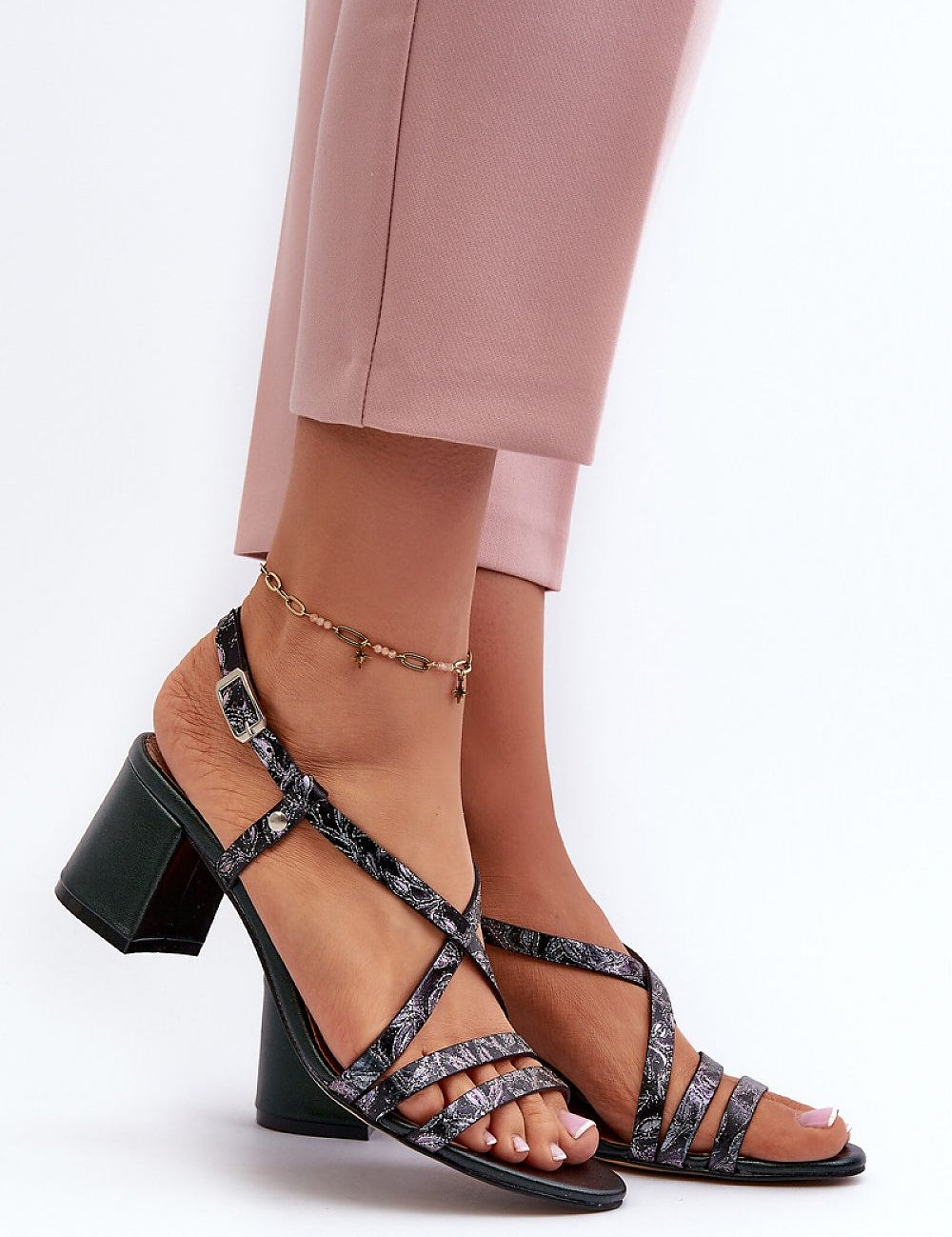 Woman wearing Arceline Leather Strap Sandals with block heels, showcasing stylish strappy design against a white background.