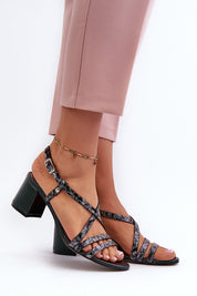 Woman wearing Arceline Leather Strap Sandals with block heels, showcasing stylish strappy design against a white background.