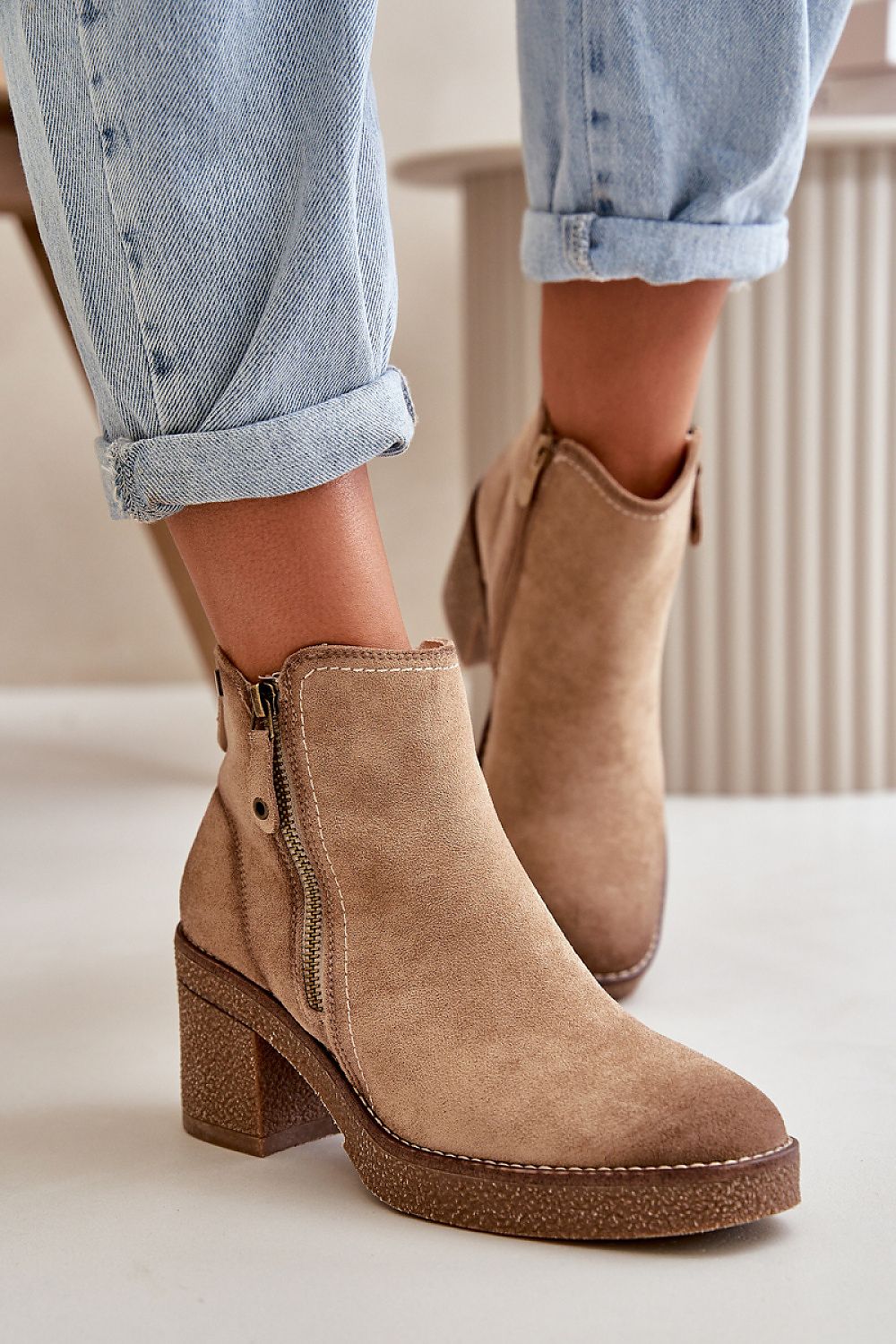 Model wearing Sylmara Hearthstep eco suede ankle boots with block heel, showing side zippers and paired with rolled-up jeans.