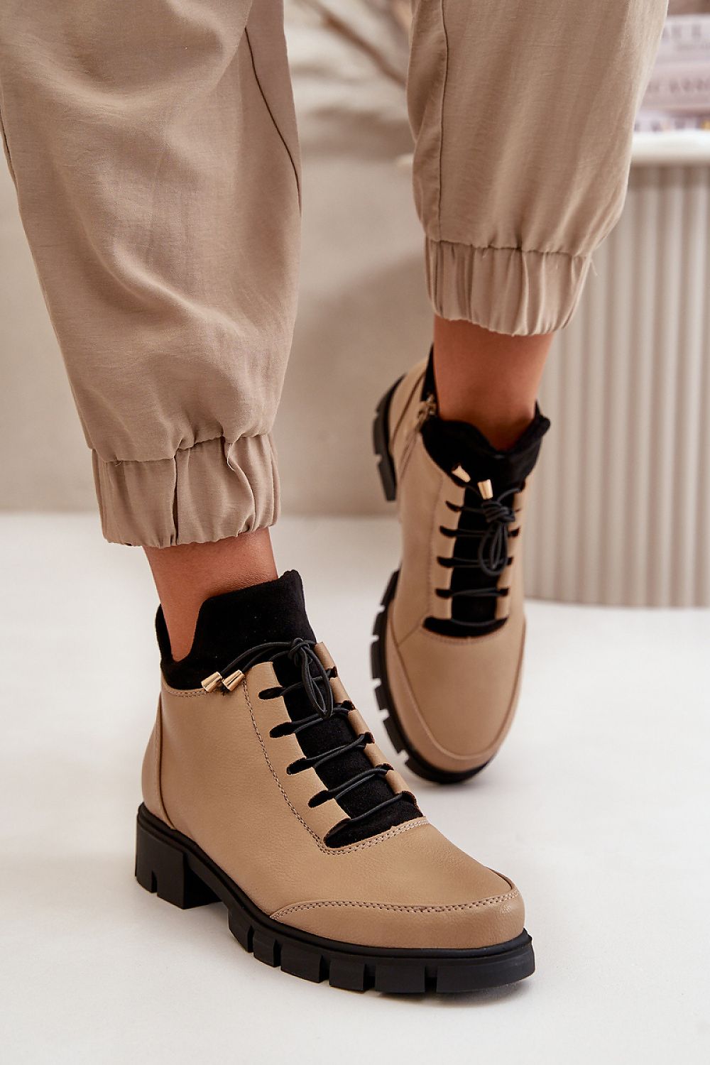 Narella Softcord Urban Base ankle boots in eco leather with black laces and side zipper, worn with beige pants.