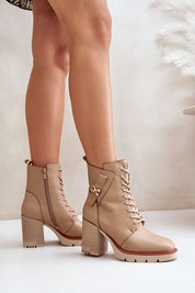 Woman wearing Noctera Luxe Zip-Up Heeled Boots in tan eco leather with block heel and gold-accented strap, side view.