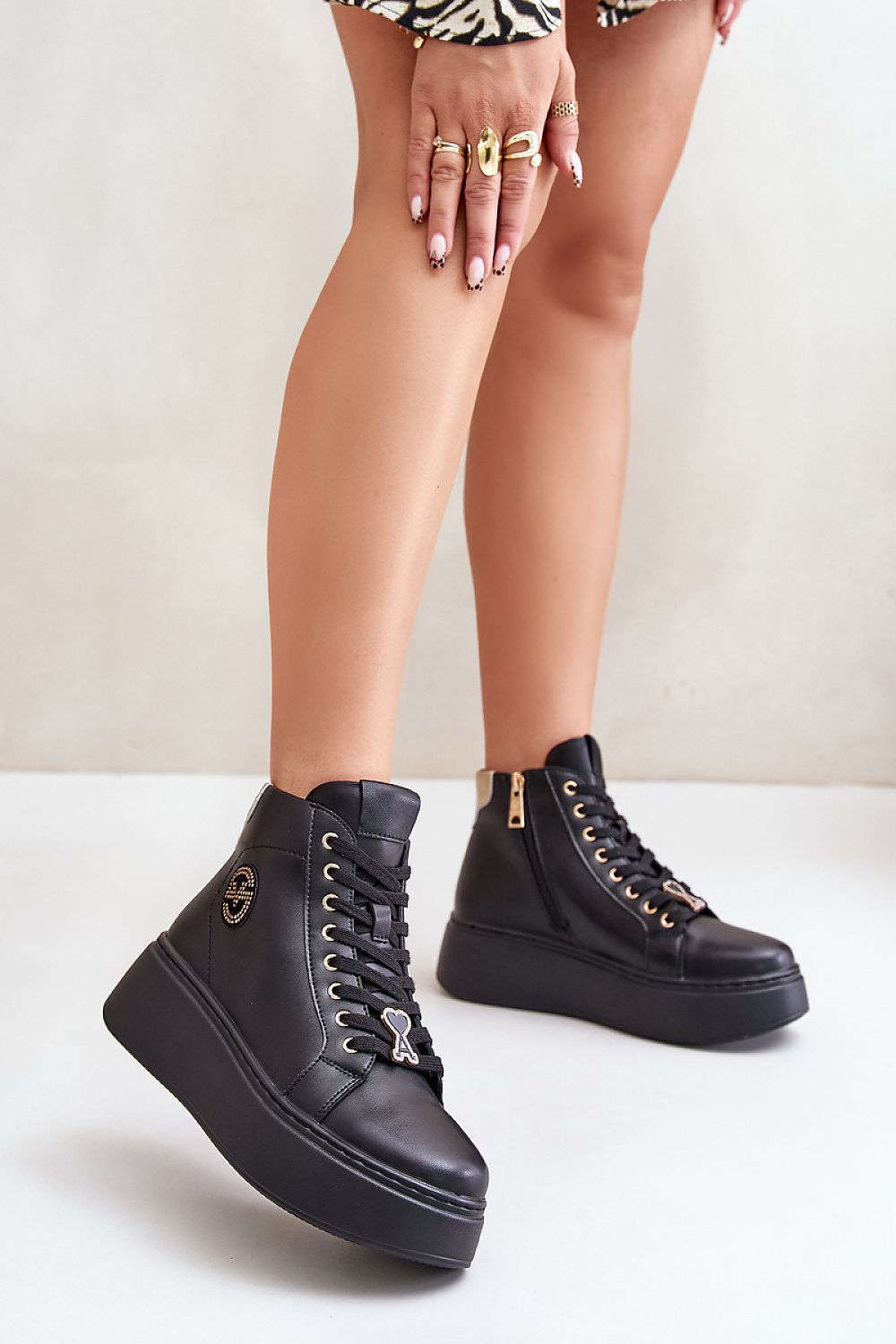 Black Ravella Leather Platform Sneakers with laces and side zipper, worn with a patterned outfit, showcasing sleek and modern style.