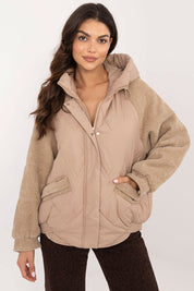 Woman wearing Velmora Quilted Hooded Jacket with corduroy sleeves and zip closure, ideal for autumn and winter urban style.