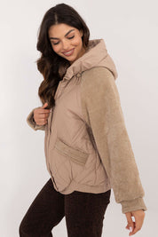 Woman wearing Velmora Quilted Hooded Jacket with corduroy sleeves, showcasing its urban style and lightweight comfort for autumn and winter.