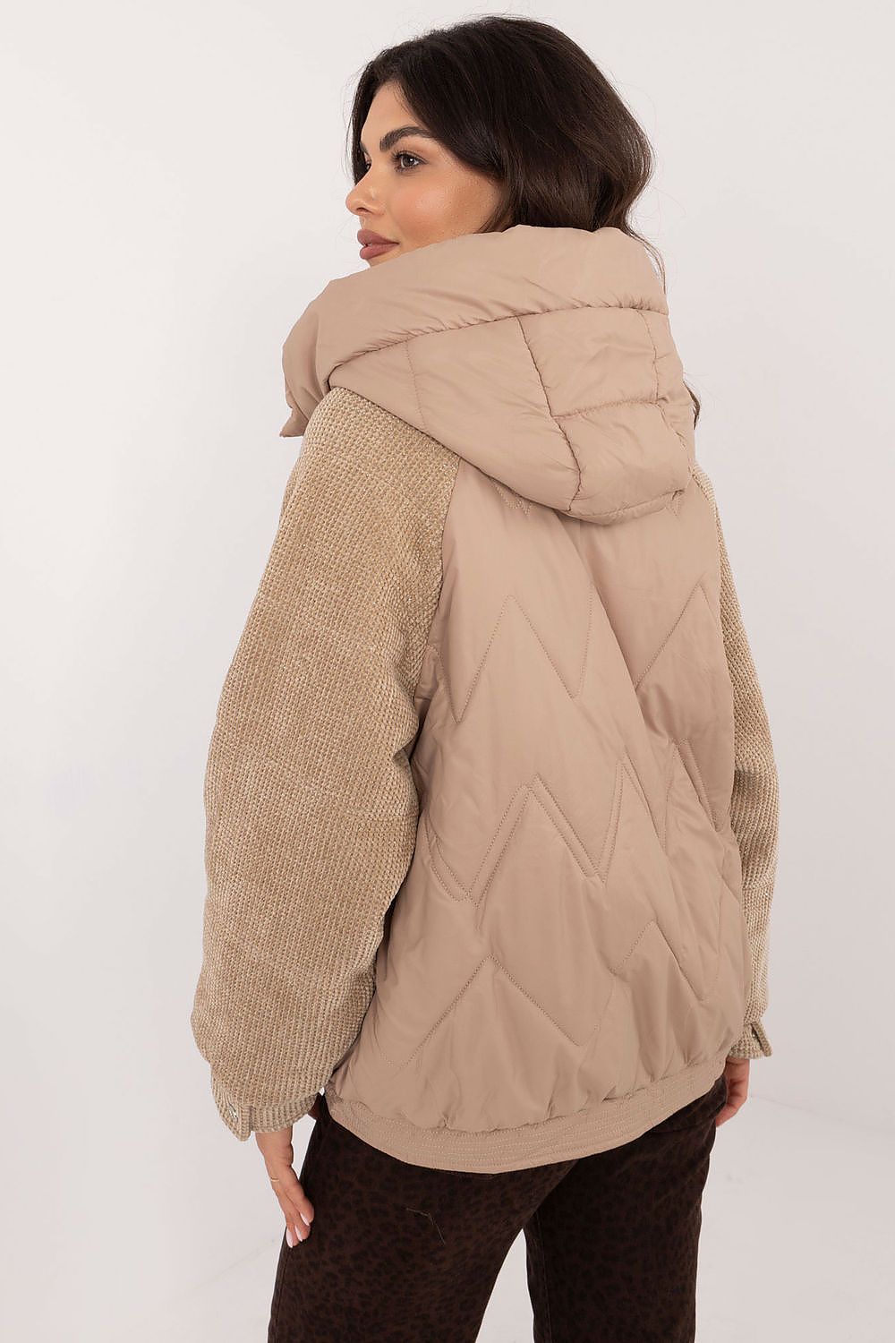 Back view of a Velmora Quilted Hooded Jacket with textured corduroy sleeves worn by a woman, showcasing urban style and comfort.