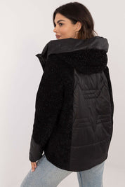 Woman wearing Velmorra Hooded Quilted Jacket in black, showing modern design and texture from back view.