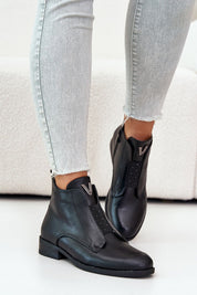 Person wearing Melvaren Zip-Up Ankle Winter Boots in black eco leather with side zipper and decorative tongue element.
