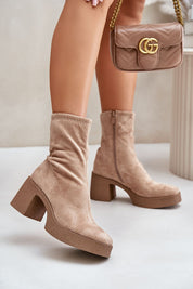 Eco suede platform heel boots with zipper closure, showcasing bold winter style and a cushioned insole for comfort, paired with a handbag.