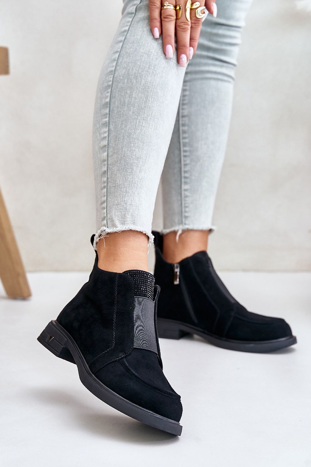 Lunavea suede ankle boots with zip, featuring a flat heel and decorative tongue detail, worn with light denim jeans for a casual look.