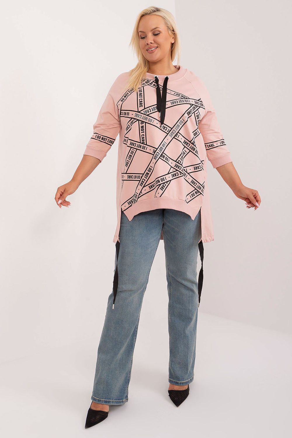 Woman wearing Elverra Plus Size Rhinestone Blouse with asymmetrical cut and rhinestone detailing, paired with jeans.