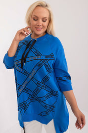 Woman wearing Elverra Plus Size Rhinestone Blouse with 3/4 sleeves and asymmetrical cut, featuring rhinestone inscriptions and round neckline.