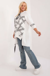 Model wearing Elverra Plus Size Rhinestone Blouse with asymmetrical cut, 3/4 sleeves, and rhinestone inscriptions, paired with jeans.