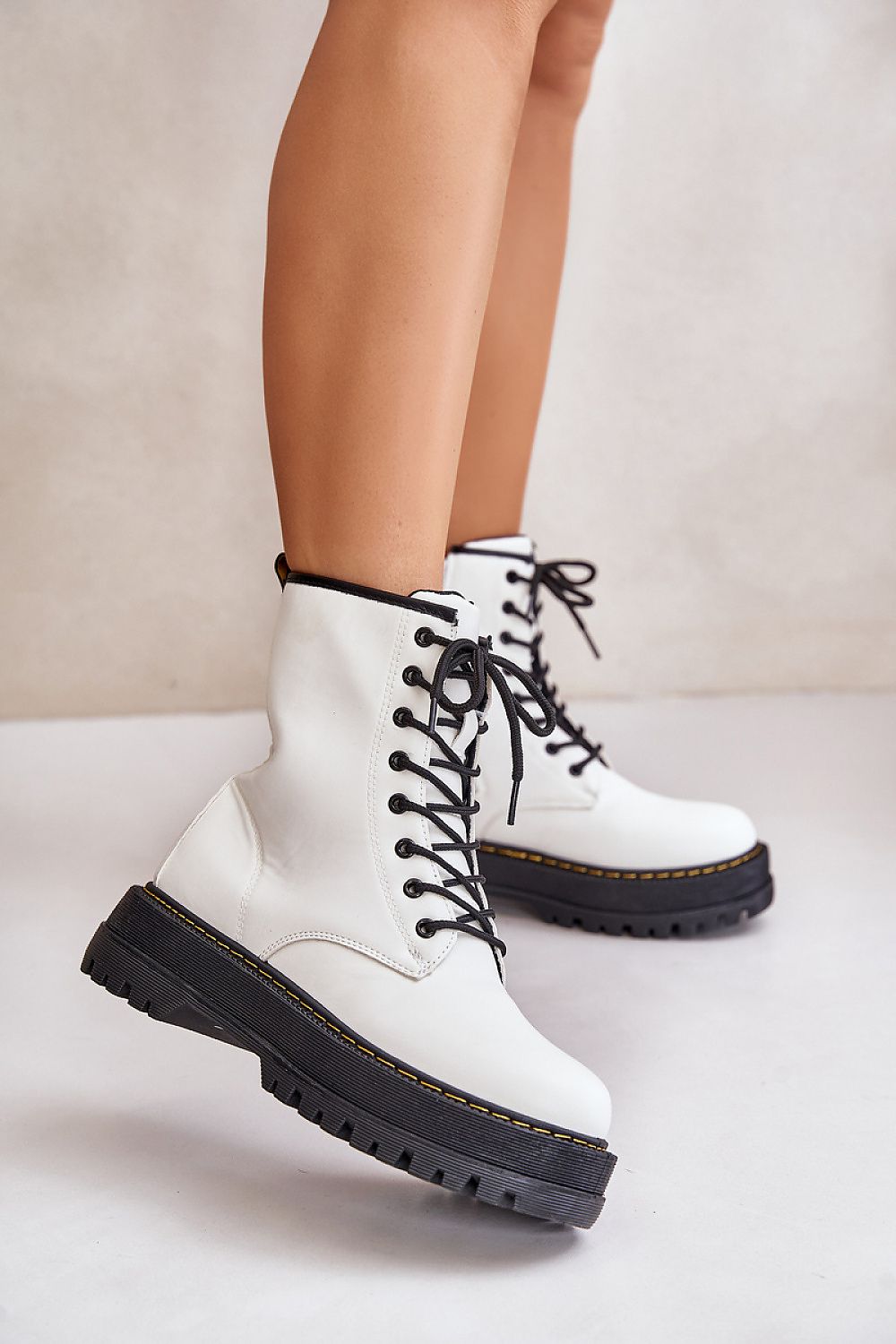Woman wearing Liravelle Corefit insulated eco leather platform boots with laces and side zipper, elevated on solid platform sole.