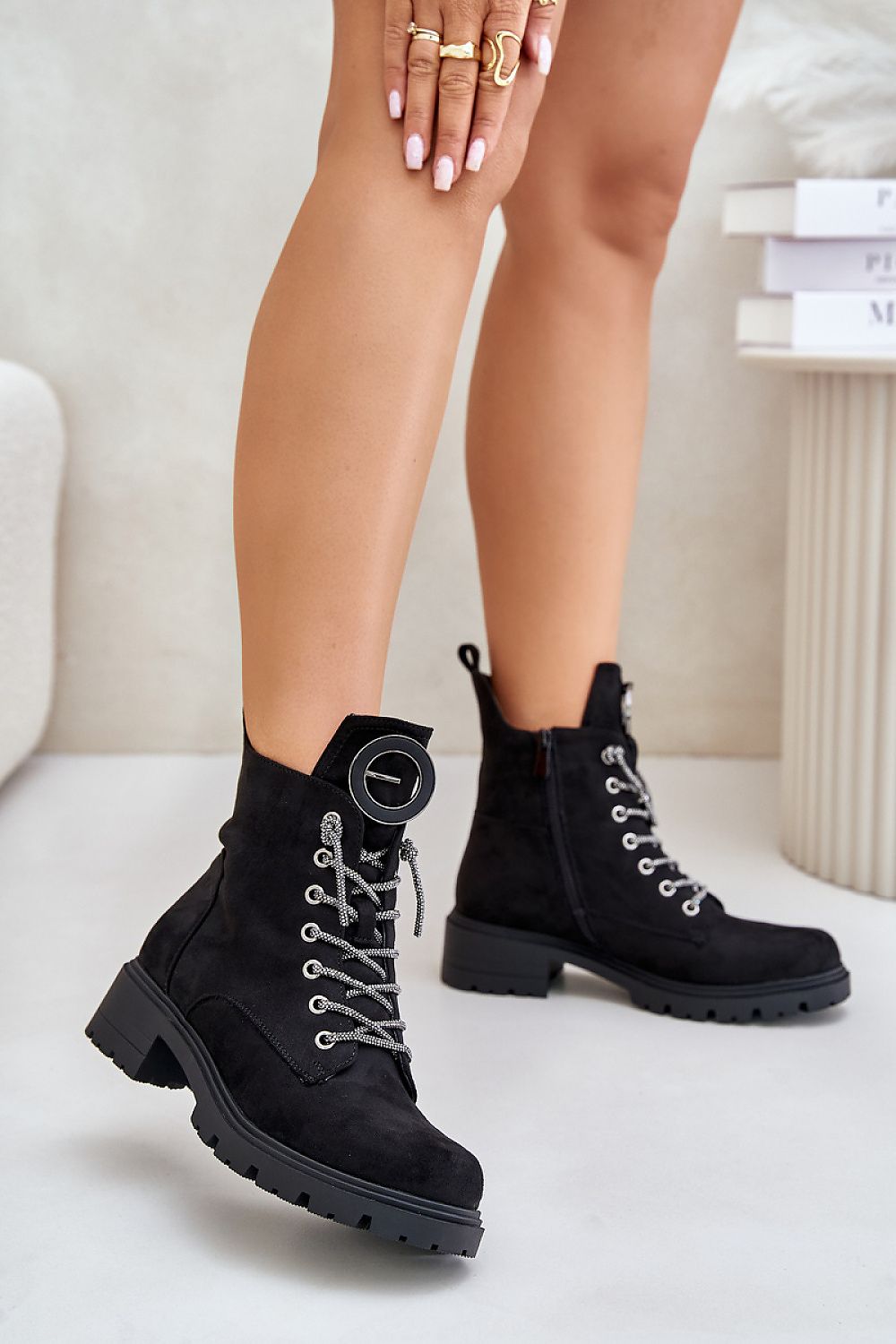 Woman wearing Virellune Frostlace Suede Rhythm boots with decorative lacing and eco-suede finish for cool-weather style.