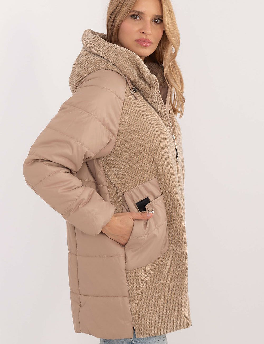 Woman wearing Cordivelle Quilted Hooded Jacket with corduroy panel and smooth quilted sections, featuring durable polyester and zip closure.