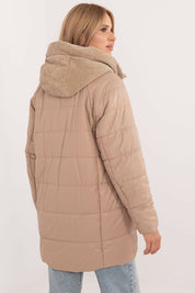 Back view of a tan Cordivelle Quilted Hooded Jacket with corduroy accents, showing quilted design and cozy hood, worn by a woman.