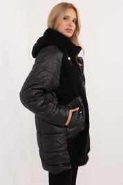 Woman wearing black Cordivelle Quilted Hooded Jacket with corduroy front and quilted panels, showcasing contemporary style and warmth.
