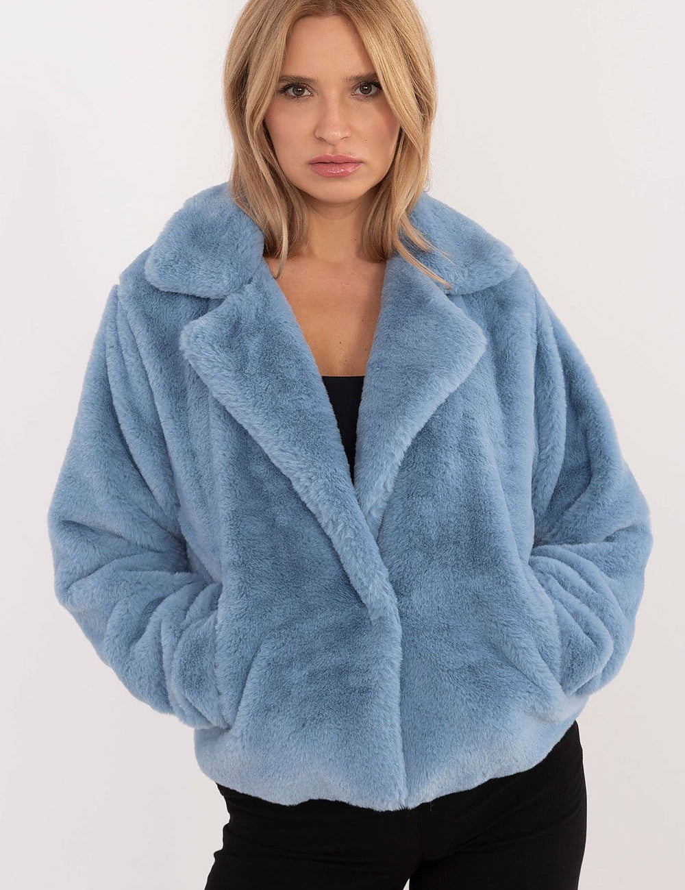 Woman wearing blue fur-collar viscose jacket with snap-front closure and slip pockets.